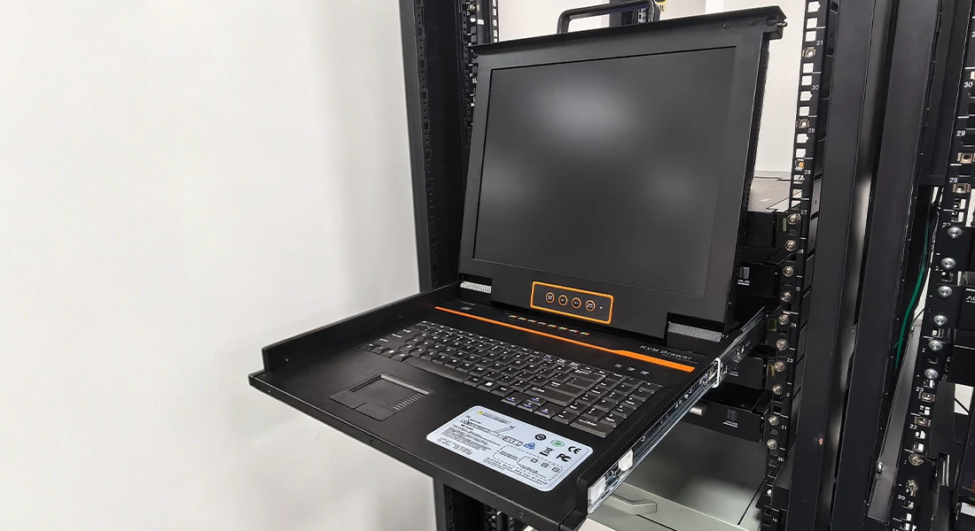 A sleek Kinan LCD KVM switch drawer fully extended from a server rack with the screen open, illustrating plug-and-play instant access and an organized, wire-free rack setup.